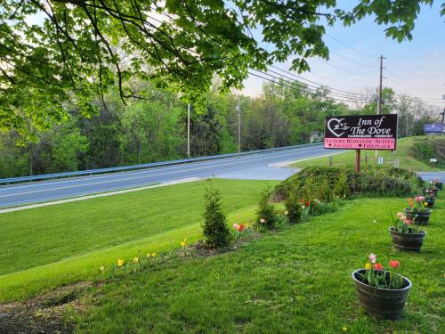 a sign for a inn with flowers on the side of a road at Inn of the Dove - Romantic Luxury Suites with Jacuzzi & Seasonal Fireplace at Harrisburg-Hershey-Philadelphia, PA in Harrisburg