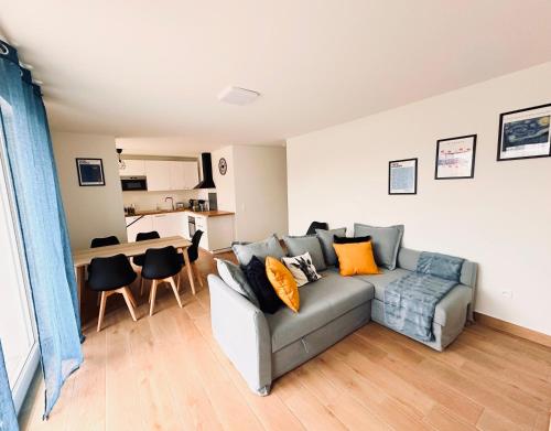 un salon avec un canapé et une cuisine dans l'établissement Grand Appart Neuf Lumineux, parking gratuit, 10 min Centre, à Strasbourg