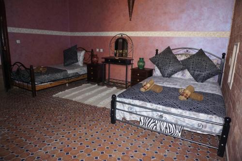 1 dormitorio con 2 camas y espejo en Riad Andalousse, en Meknès