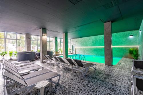 a pool room with chairs and a swimming pool at Konopka Forest Home & SPA in Bukovel