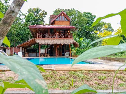 a villa with a pool and a house at Sigiriya Elegant Resort in Sigiriya