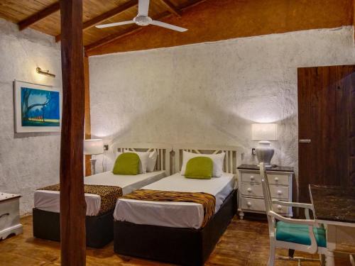 a bedroom with two beds and a table and chairs at Sigiriya Elegant Resort in Sigiriya