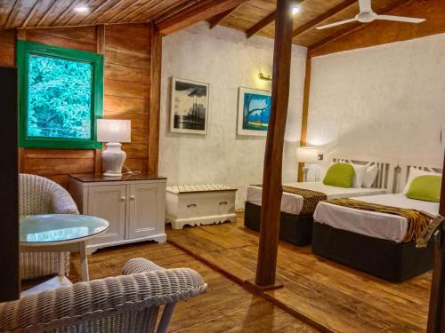 a bedroom with two beds and a table and chairs at Sigiriya Elegant Resort in Sigiriya