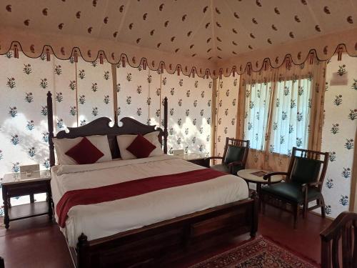 - une chambre avec un lit, une table et des chaises dans l'établissement Royal Pushkar Camps- a Luxury Camp Resort, à Pushkar