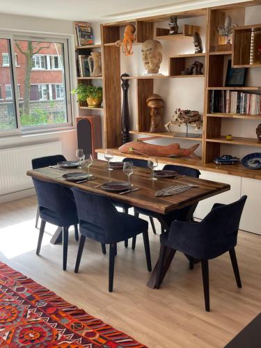 une salle à manger avec une table et des chaises en bois dans l'établissement Appartement style galerie d'art avec parking, à Paris