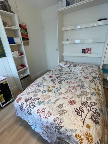 une chambre avec un lit avec un couvre-lit fleuri dans l'établissement Appartement style galerie d'art avec parking, à Paris