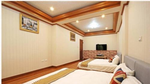 台南的住宿－宿曦 Suxi House，一间卧室配有两张床和电视。