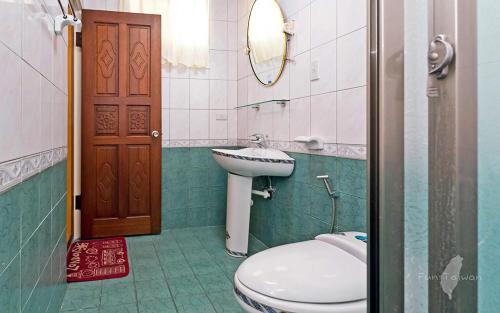 台南的住宿－宿曦 Suxi House，一间带卫生间、水槽和镜子的浴室