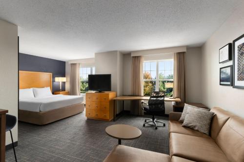 um quarto de hotel com uma cama e um sofá em Residence Inn Neptune at Gateway Center em Neptune City
