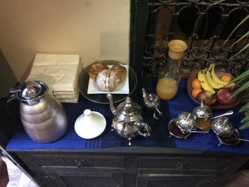 a table with a blue counter top with a plate of fruit at Riad Paquerette in Marrakesh