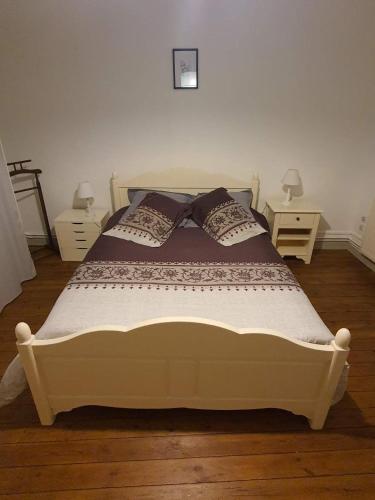 een wit bed met kussens in een slaapkamer bij Maison d'hôtes du Faubourg Charrault Saint Maixent L'Ecole in Saint-Martin-de-Saint-Maixent