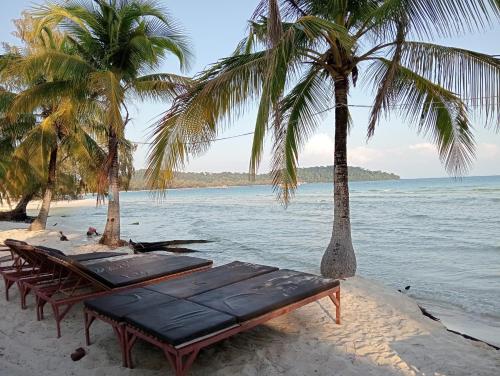 un grupo de mesas y palmeras en una playa en White Pearl Beach, en Kaôh Rŭng (3)