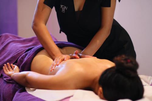 a woman getting a back massage from a woman on a bed at Gillieru Harbour Hotel in St Paul's Bay