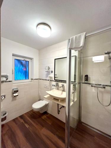 uma casa de banho com um WC, um lavatório e um chuveiro em Waldgasthof Im Schwall em Nastätten