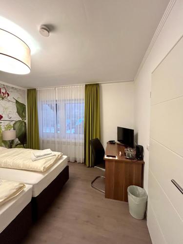 um quarto de hotel com uma cama e uma secretária com um computador em Waldgasthof Im Schwall em Nastätten
