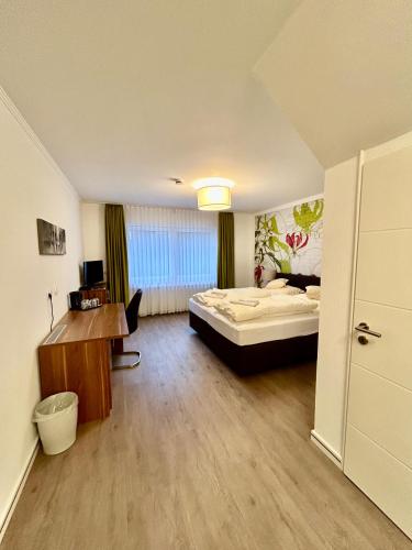 1 dormitorio con 1 cama y escritorio en una habitación en Waldgasthof Im Schwall en Nastätten