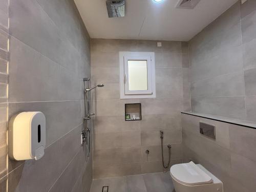 a bathroom with a toilet and a window at R61 Sunset Chalet in Muntarib