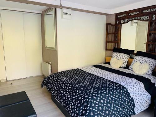 1 dormitorio con 1 cama con edredón azul y blanco en Hameau de la Jonquiere 4, en Lapeyrouse-Fossat