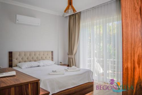 a bedroom with a bed and a large window at BegonVilla Fethiye-Göcek in Muğla