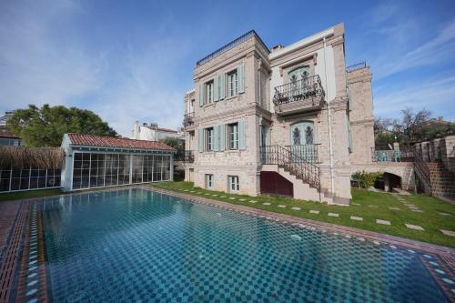uma casa grande com uma piscina em frente em Naz Su Cunda em Cunda