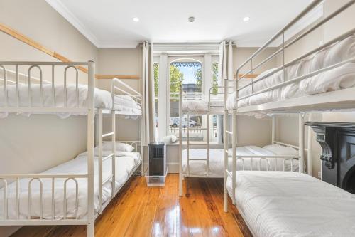 a room with four bunk beds and a fireplace at Azzurro Boutique Hotel - Surry Hills in Sydney