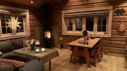a living room with a couch and a table and a fireplace at Liaplassen Fjellhytte in Beitostøl