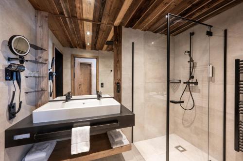 a bathroom with a sink and a shower at Austria Alpinhotel in Obertauern