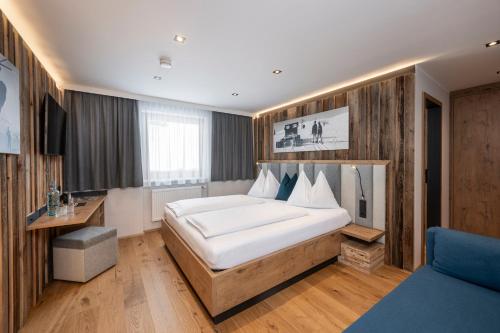 ein Schlafzimmer mit einem großen weißen Bett in einem Zimmer in der Unterkunft Austria Alpinhotel in Obertauern