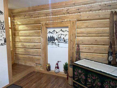 a room with a wooden wall with a painting on it at Pokoje regionalne u Ani in Zakopane