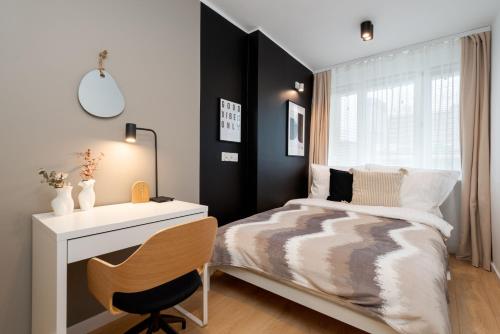 a bedroom with a bed and a desk and a chair at Kairos Apartments - New York Premium- darmowy parking, ścisłe centrum, Spodek in Katowice