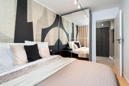 een slaapkamer met een groot bed en een spiegel bij Apartament New York Premium- ścisłe centrum - by Kairos Apartments in Katowice