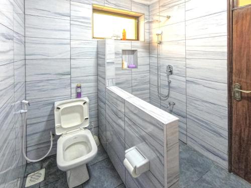 a bathroom with a toilet and a shower at Casa Marabella A2 in Diani Beach