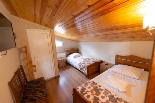 a small room with two beds and a tv at Hotel Zemo Aragvi in Gudauri