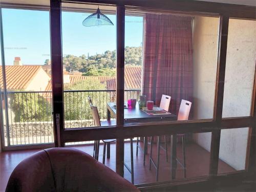 Cette chambre dispose d'une table et offre une vue sur un balcon. dans l'établissement 5VSE-LAM4 appartement Faubourg T2 proche plage vue dégagée, à Collioure