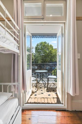 a bedroom with a door open to a balcony with a table at Azzurro Boutique Hotel - Surry Hills in Sydney