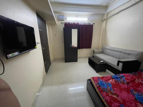 a small living room with a couch and a tv at Lakeview Apartments Homestay in Agartala