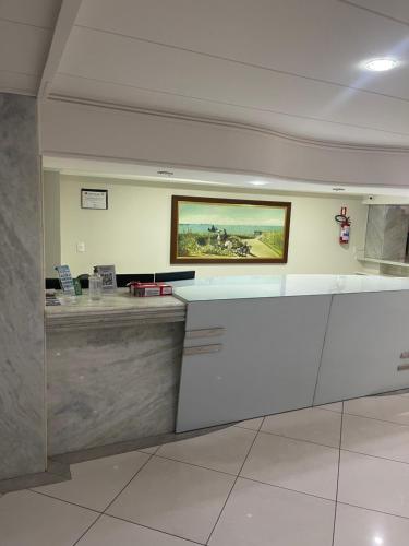 a lobby with a counter with a painting on the wall at APART HOTEL MANAÍRA PALACE in João Pessoa