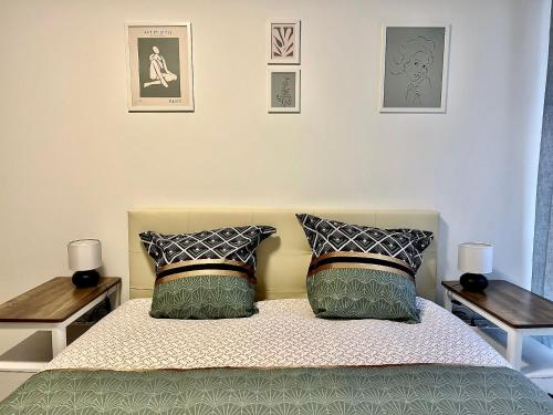 - une chambre avec un lit avec deux tables et deux oreillers dans l'établissement Grand Appart Neuf Lumineux, parking gratuit, 10 min Centre, à Strasbourg