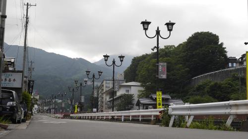 a city street with street lights and a mountain at Shibu Onsen Koishiya Ryokan in Yamanouchi
