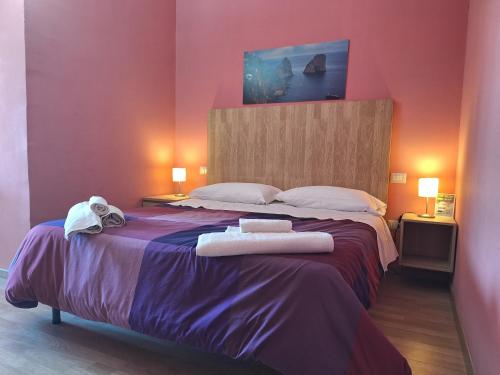 een slaapkamer met een groot bed en handdoeken bij Napoli Royal Suite in Napels