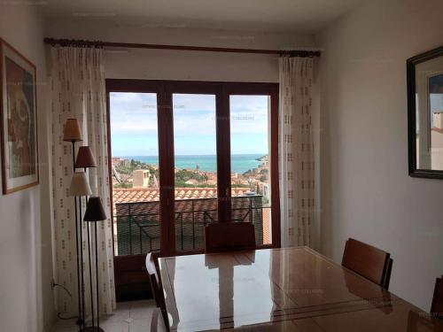 Zimmer mit einem Glastisch und einem großen Fenster in der Unterkunft 6CHK4 Villa 6 personnes dans résidence in Collioure
