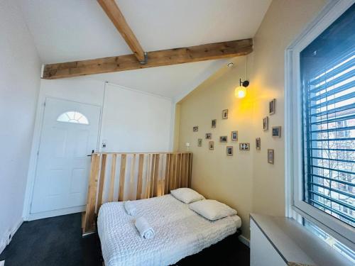 1 dormitorio con 1 cama en una habitación con ventana en Maison d'hôtes à 2 pas de Paris, en Les Lilas