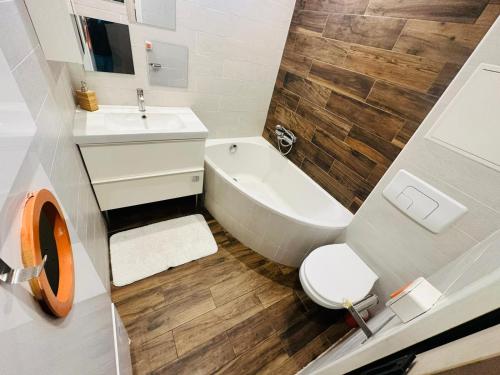 a bathroom with a tub and a toilet and a sink at Maison d'hôtes à 2 pas de Paris in Les Lilas