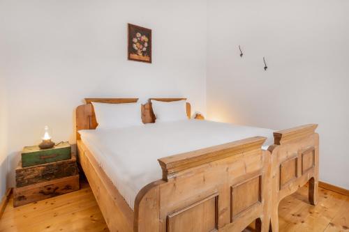 Schlafzimmer mit einem Holzbett mit weißer Bettwäsche in der Unterkunft Rustic Visual in Oradea