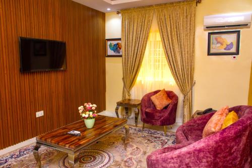 a living room with two chairs and a tv at ERiTH APARTMENT & SUITES in Ikeja