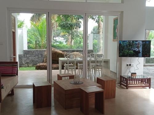 a living room with a table and a dining room at Samalanka Boutique Hotel in Habaraduwa