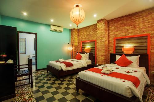 um quarto de hotel com duas camas e um lustre em RESIDENCE 1960 em Siem Reap