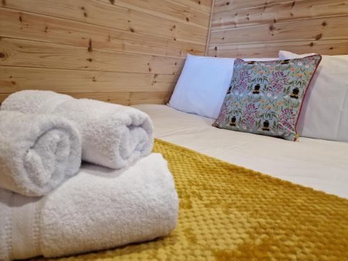 Gorse Gorgeous Glamping Hideaway في Dundonnell: سرير عليه حشره محشوه مع مخده