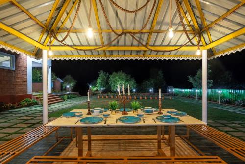 a table under a tent in a garden at night at Malibu Villa by Hill Staytion in Panchgani