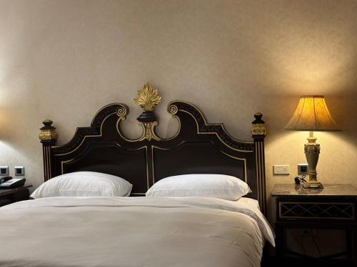 um quarto com uma cama grande e 2 almofadas brancas em Grand Pleasure Spring Hotel em Taipei